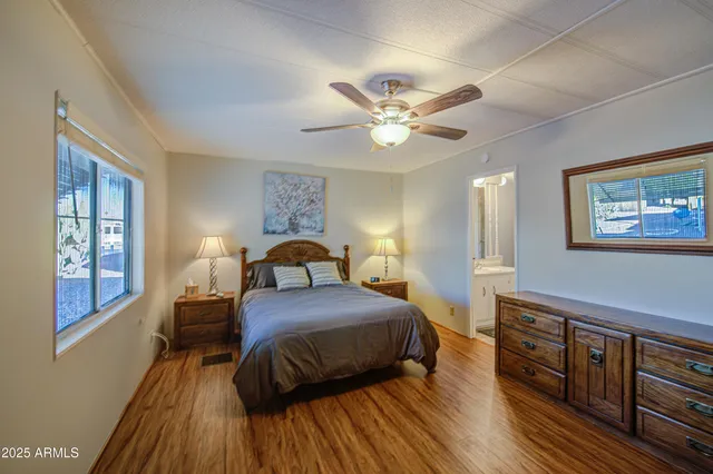 a bedroom with a bed dresser and wooden floor