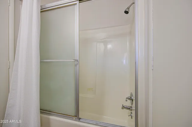 a bathroom with a glass shower door