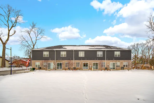 a front view of a house with a snow on the road