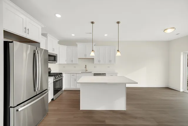 a kitchen with kitchen island a sink stainless steel appliances and cabinets