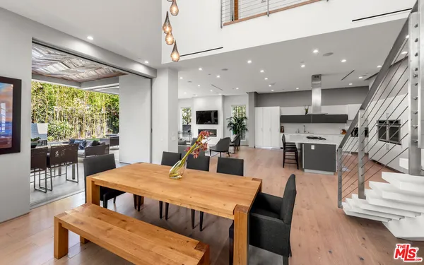 a view of a dining room with furniture a kitchen and chandelier