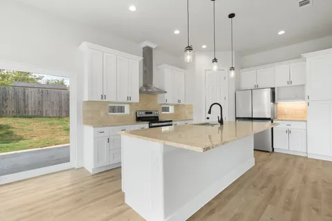 a large kitchen with kitchen island a sink stainless steel appliances and cabinets