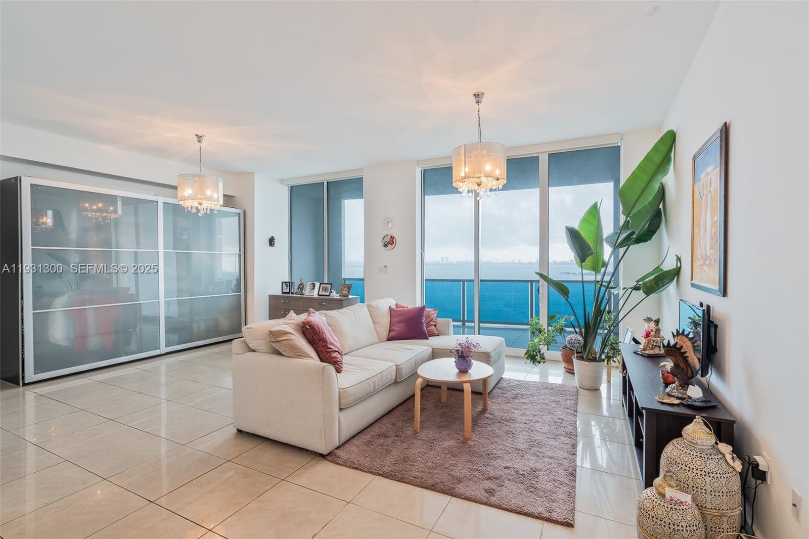 725 Northeast 22nd Street, Unit 9E Miami, FL 33137 - Photo 2 of 12 a living room with furniture and a chandelier
