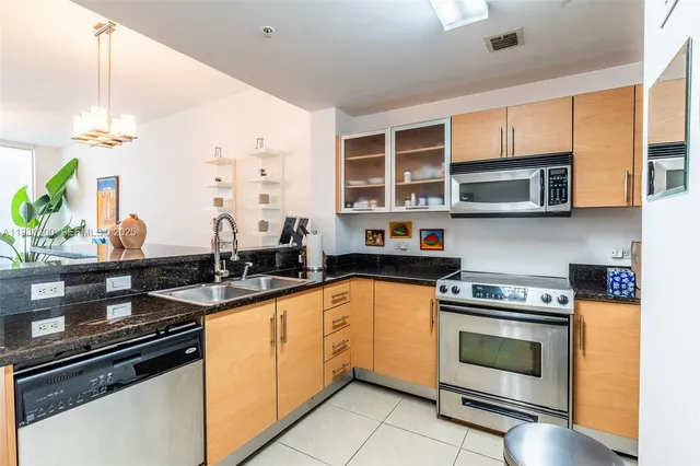 a kitchen with stainless steel appliances a stove sink and cabinets