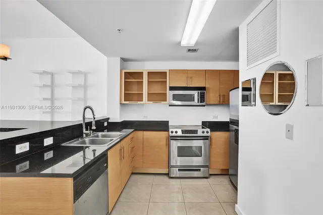 a kitchen with stainless steel appliances granite countertop a stove a sink and a microwave