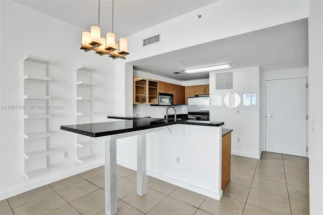 a kitchen with stainless steel appliances granite countertop a sink and a refrigerator