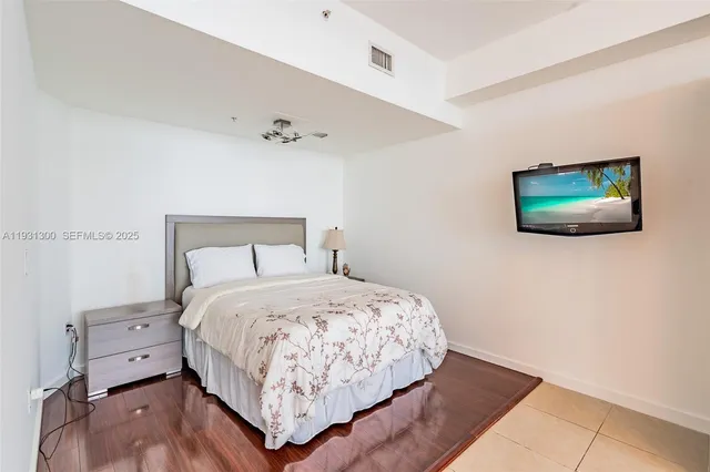 a bedroom with a bed and painting on the wall