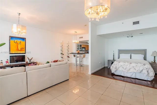 a bedroom with a bed and a chandelier