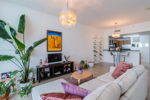 a living room with furniture a chandelier and a flat screen tv