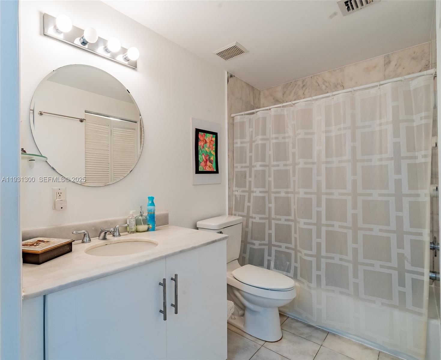 725 Northeast 22nd Street, Unit 9E Miami, FL 33137 - Photo 10 of 12 a bathroom with a sink a toilet and a mirror