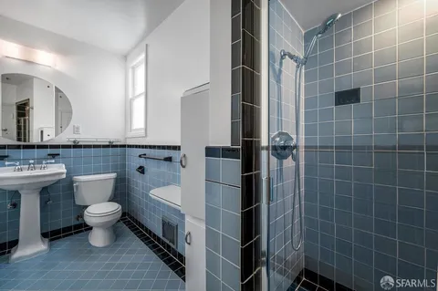 a bathroom with a toilet sink and mirror