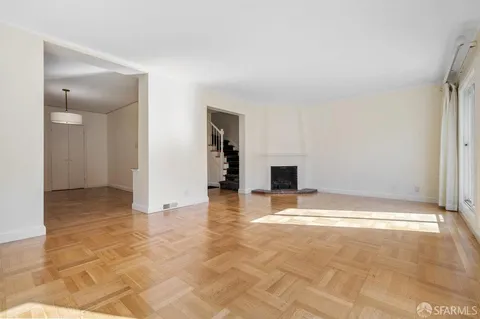 a view of an empty room with a fireplace and a window
