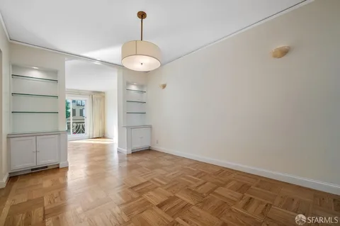 a view of a room with wooden floor staircase and a kitchen space