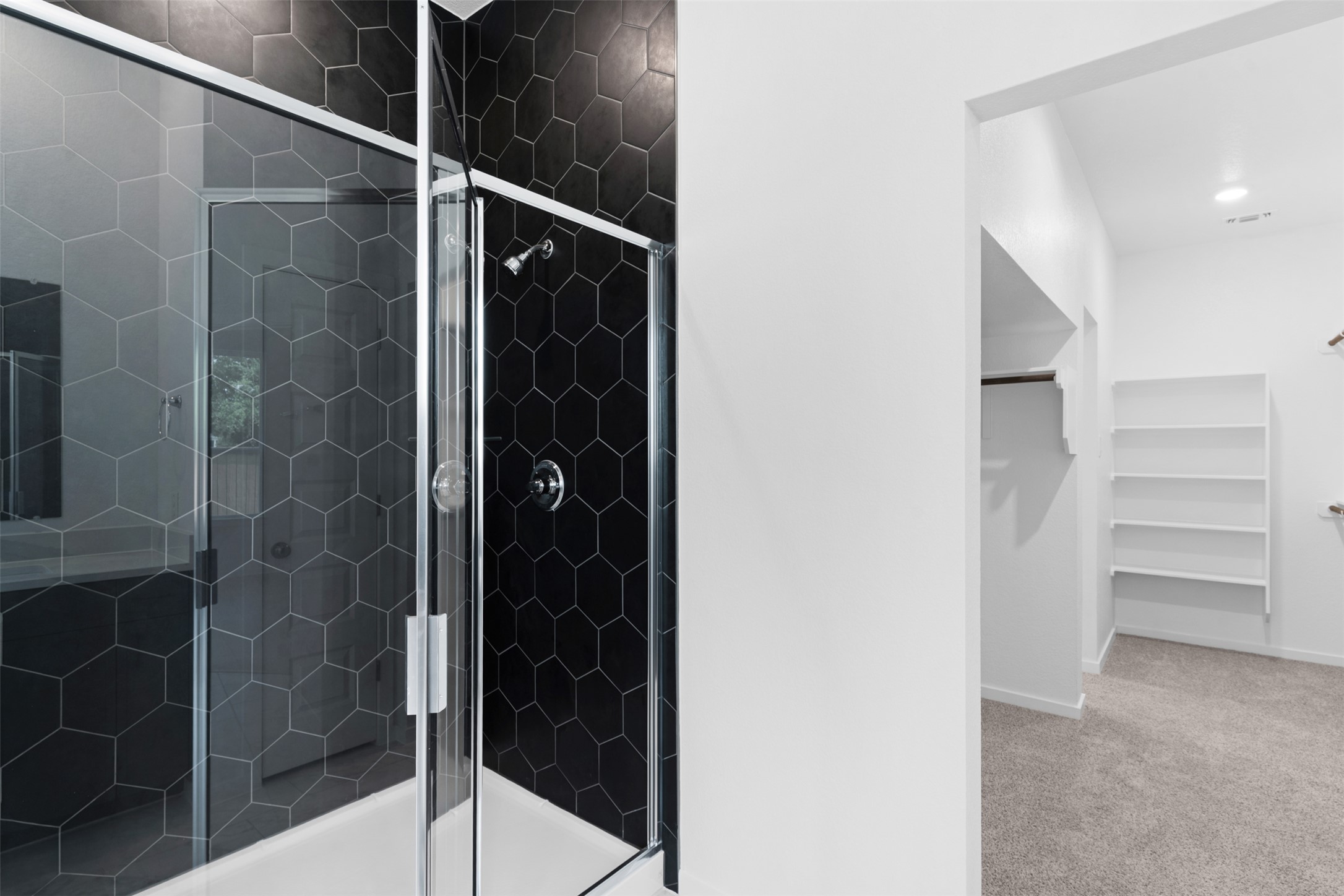 316 Ridgewell Loop Georgetown, TX 78633 - Photo 12 of 25 The bathroom features a shower with glass doors and dark hexagonal tile walls