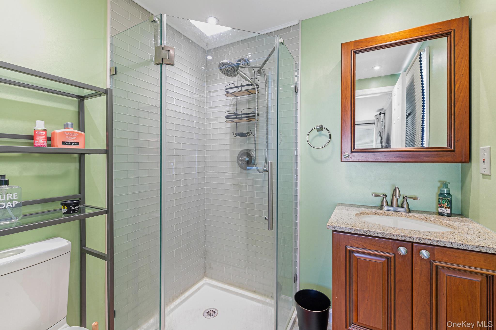33 Lillian Road Nesconset, NY 11767 - Photo 18 of 42 The Beautifully Renovated Second Full Bathroom (En Suite Off Of The Third Bedroom) Offers A Custom Corner Shower With All Subway Tiled Walls, Frameless Glass Doors, Ceramic Tiled Floor, Granite Topped Vanity & All Upgraded Fixtures.
