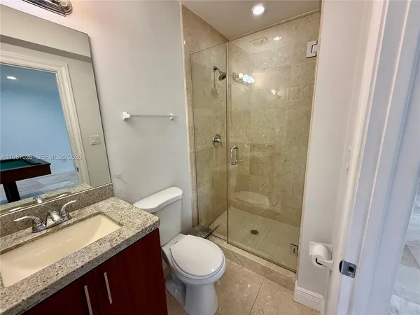 a bathroom with a granite countertop sink toilet and shower
