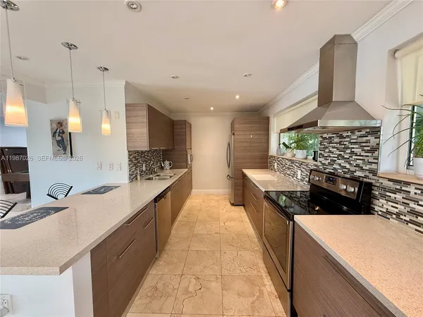a large kitchen with kitchen island a sink stove and cabinets