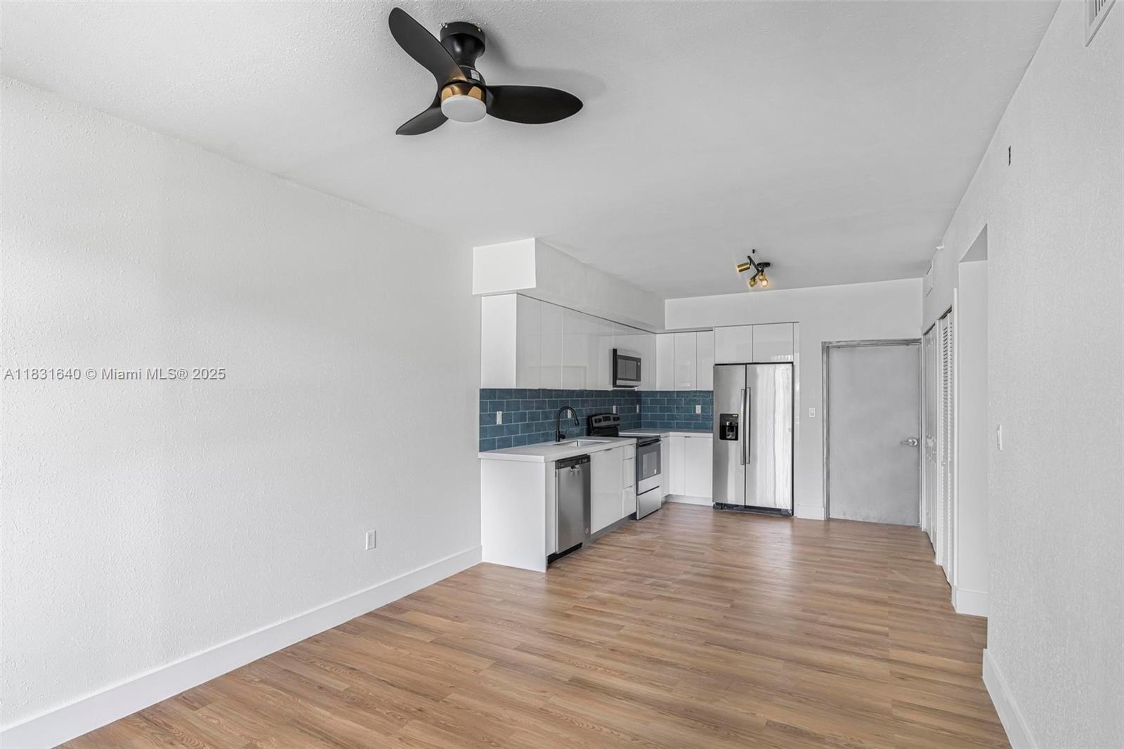 16955 Southwest 100th Avenue Miami, FL 33157 - Photo 18 of 42 a kitchen with a refrigerator and white cabinets