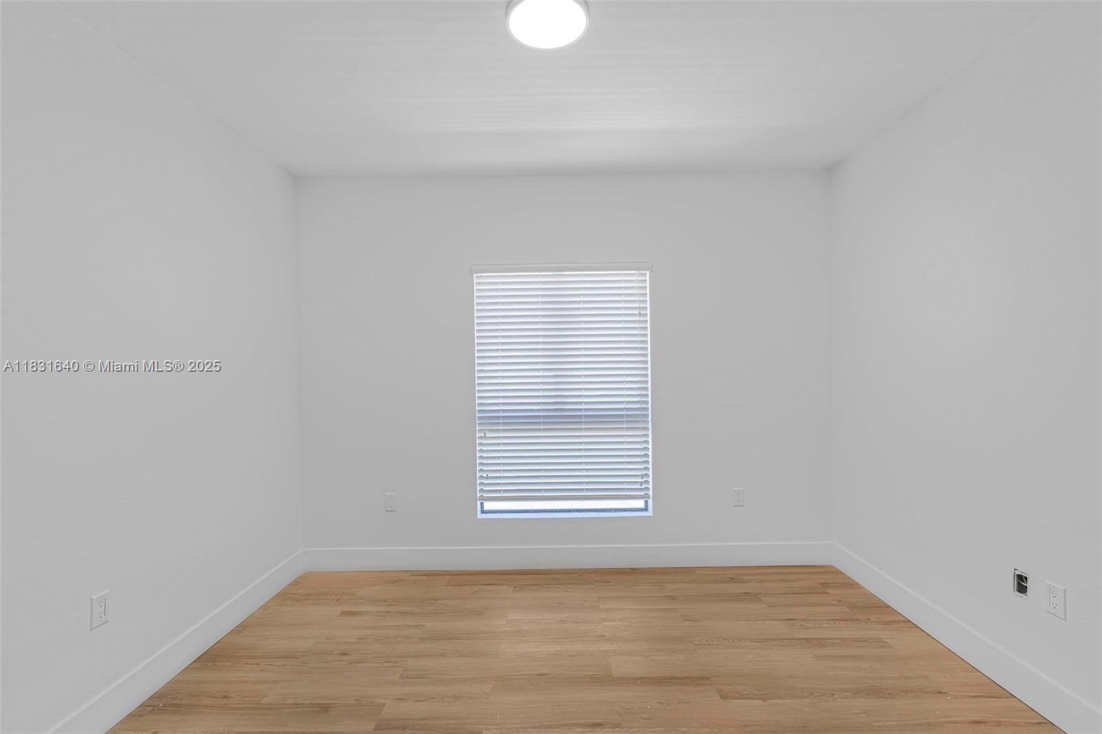 16955 Southwest 100th Avenue Miami, FL 33157 - Photo 29 of 42 a view of an empty room with wooden floor and a window