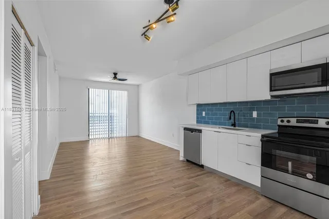 a kitchen with granite countertop a stove cabinets and wooden floor