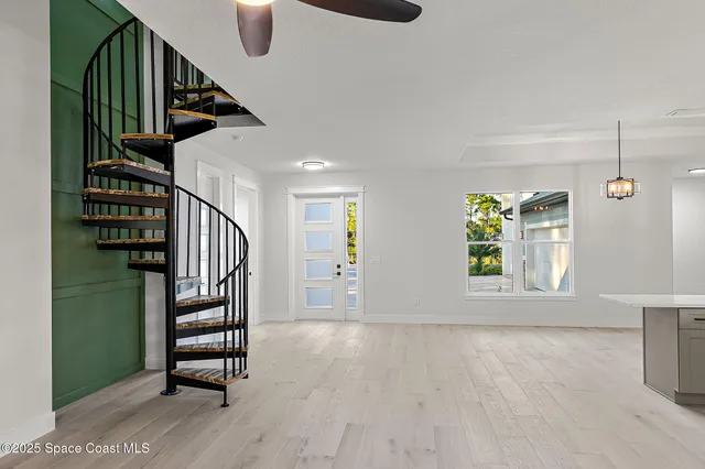 a large white kitchen with large windows and refrigerator