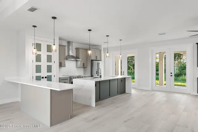 an empty room with windows and ceiling fan