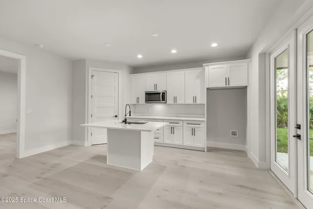 an empty room with wooden floor and mirror