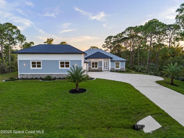 a front view of a house with a garden and yard