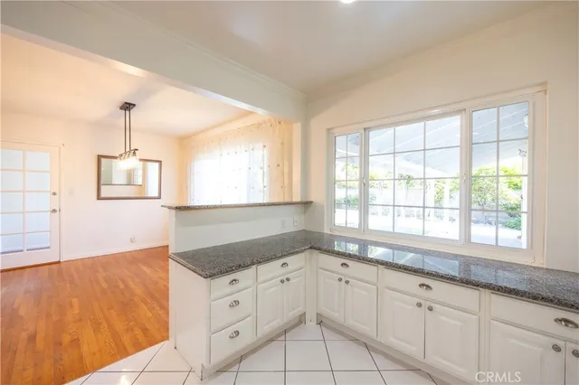 a kitchen with granite countertop white cabinets and a large window