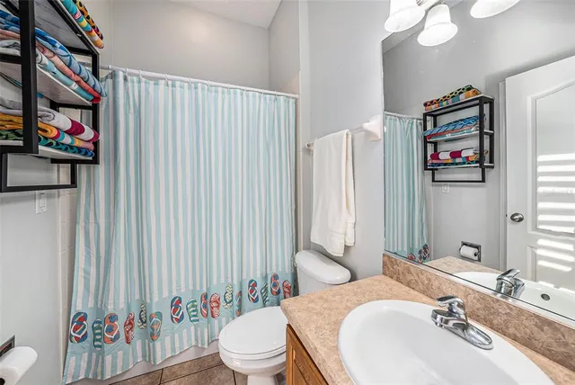 a bathroom with a sink a toilet and a shower curtain