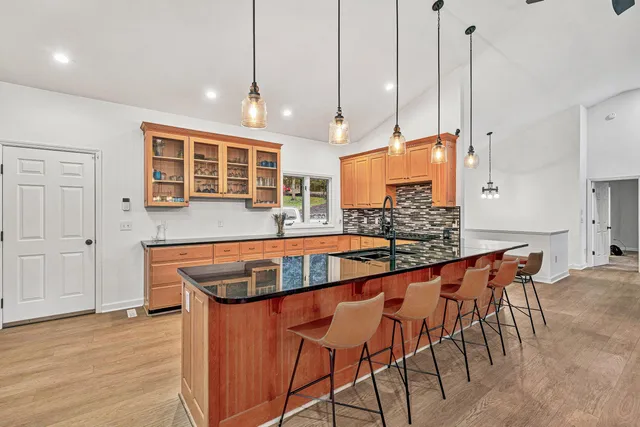 a kitchen with stainless steel appliances granite countertop a stove and a wooden floors