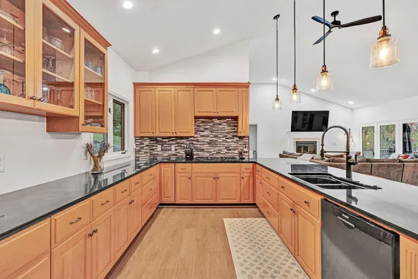 a kitchen with granite countertop a sink a counter space appliances and cabinets