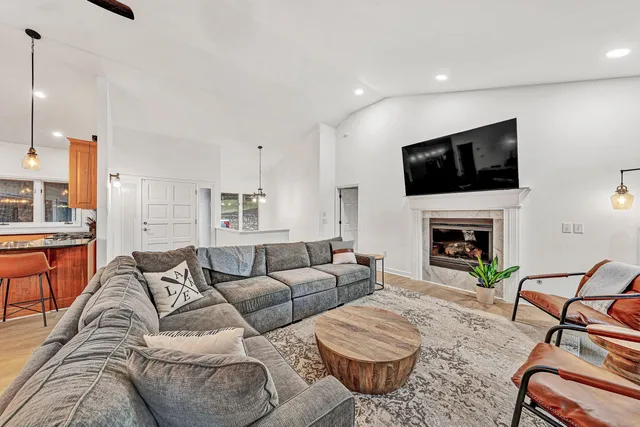 a living room with furniture a fireplace and a flat screen tv