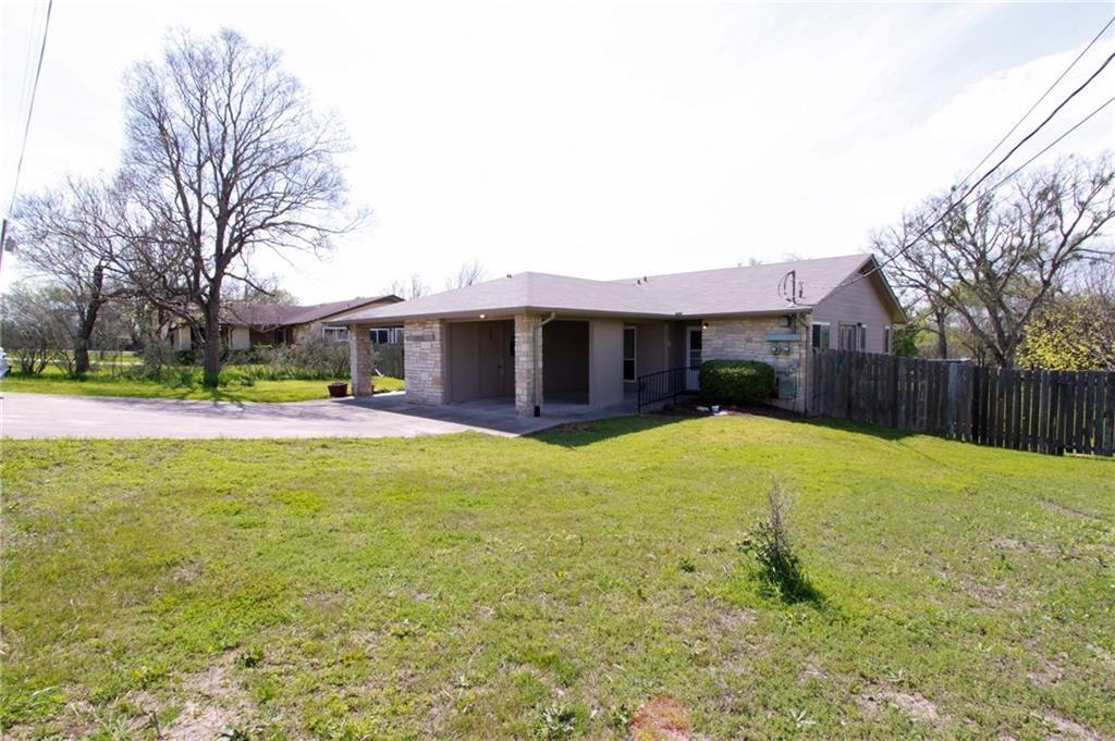 12902 Old San Antonio Road, Unit A Manchaca, TX 78652 - Photo 1 of 9 Single-story residence featuring a stone and stucco exterior, covered carport, and a private wooden fence