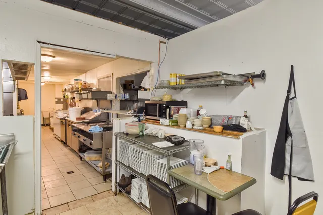 a kitchen with stainless steel appliances granite countertop a refrigerator a stove and a wooden floors