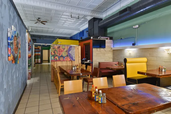 a living room with furniture a flat screen tv and kitchen view