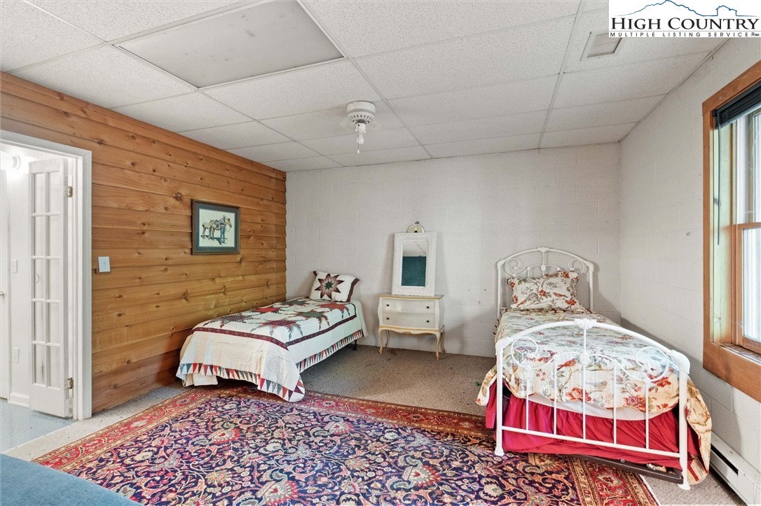 208 Hawkbill Road Ferguson, NC 28624 - Photo 23 of 36 a bedroom with a bed and wooden floor