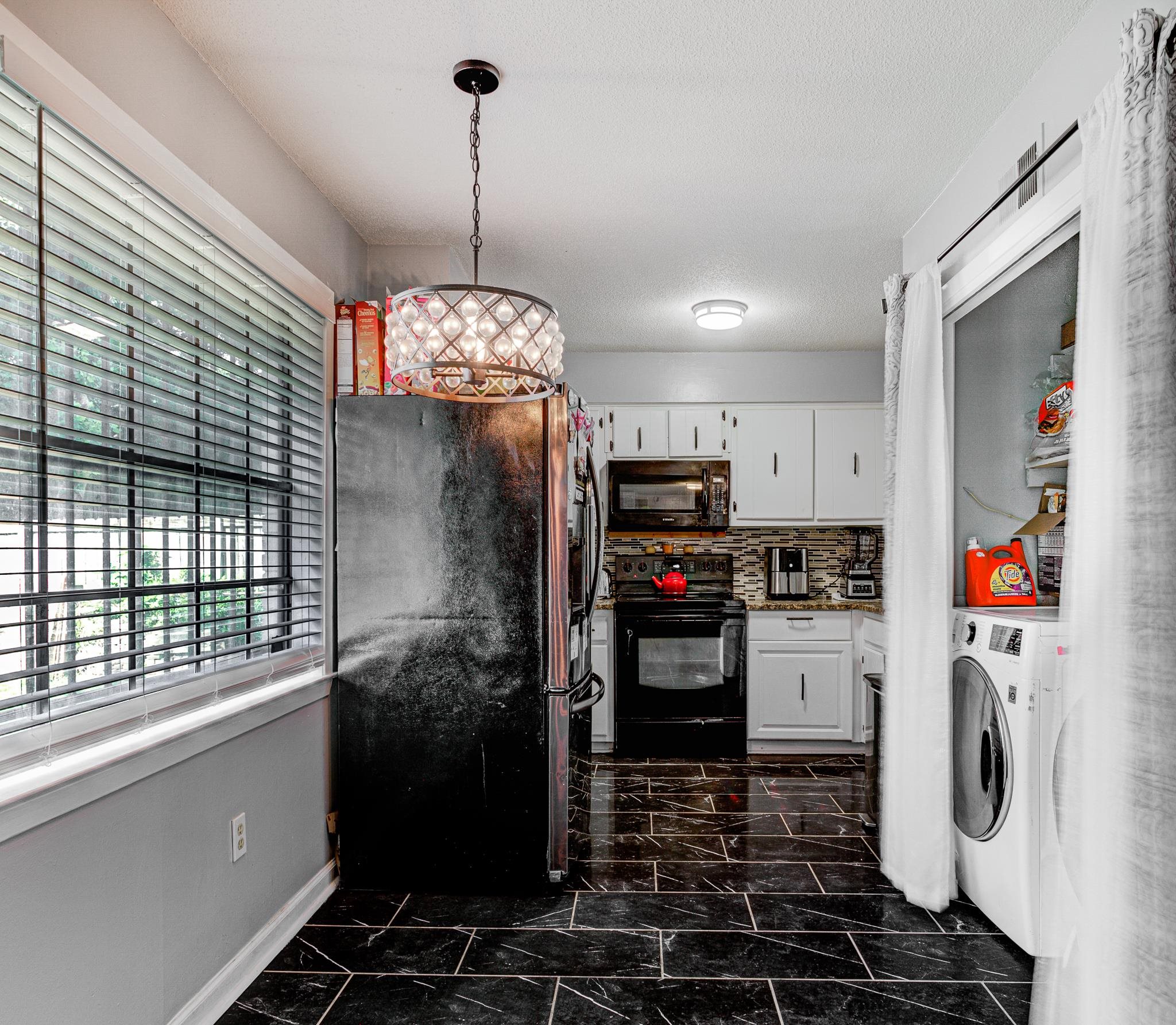 6044 Raintree Drive Memphis, TN 38115 - Photo 8 of 22 Kitchen featuring black appliances, dark marble finish floors, white cabinetry, decorative backsplash, and pendant lighting