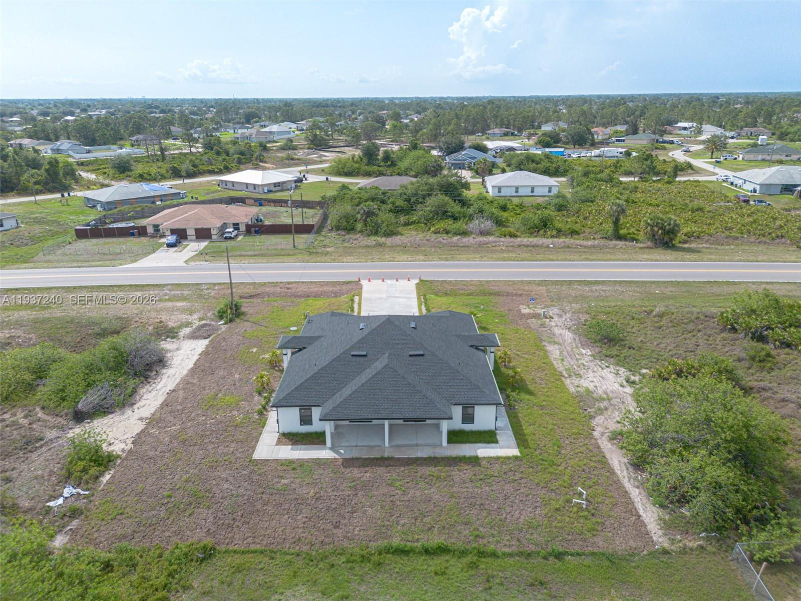 842-844 Alabama Road South Lehigh Acres, FL 33974 - Photo 12 of 40 an aerial view of a house with a yard and lake view