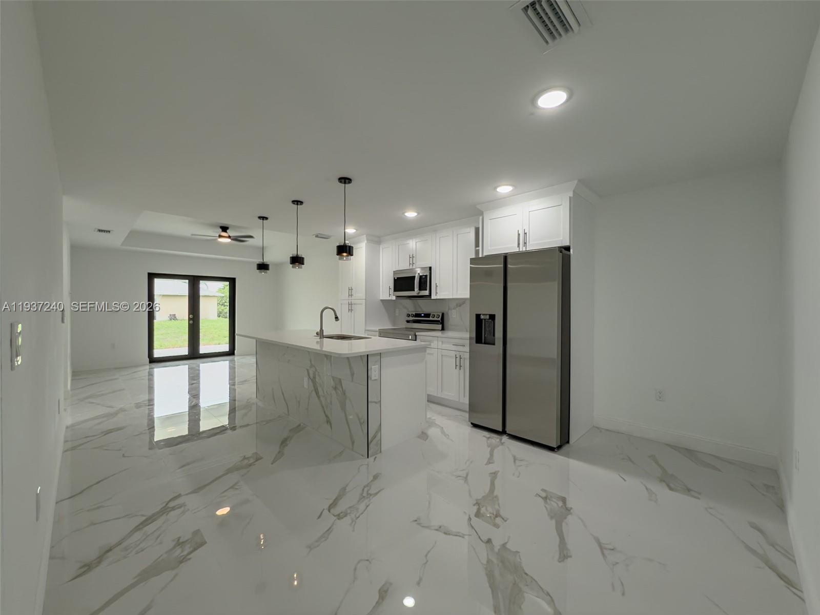 842-844 Alabama Road South Lehigh Acres, FL 33974 - Photo 18 of 40 a kitchen with refrigerator and white cabinets