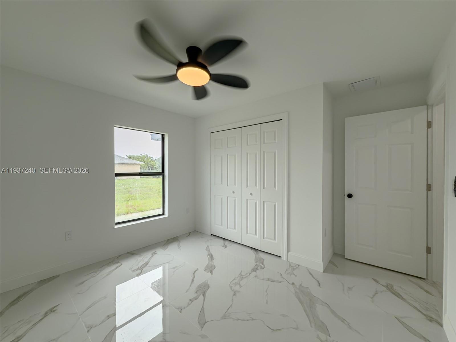 842-844 Alabama Road South Lehigh Acres, FL 33974 - Photo 25 of 40 an empty room with windows and ceiling fan