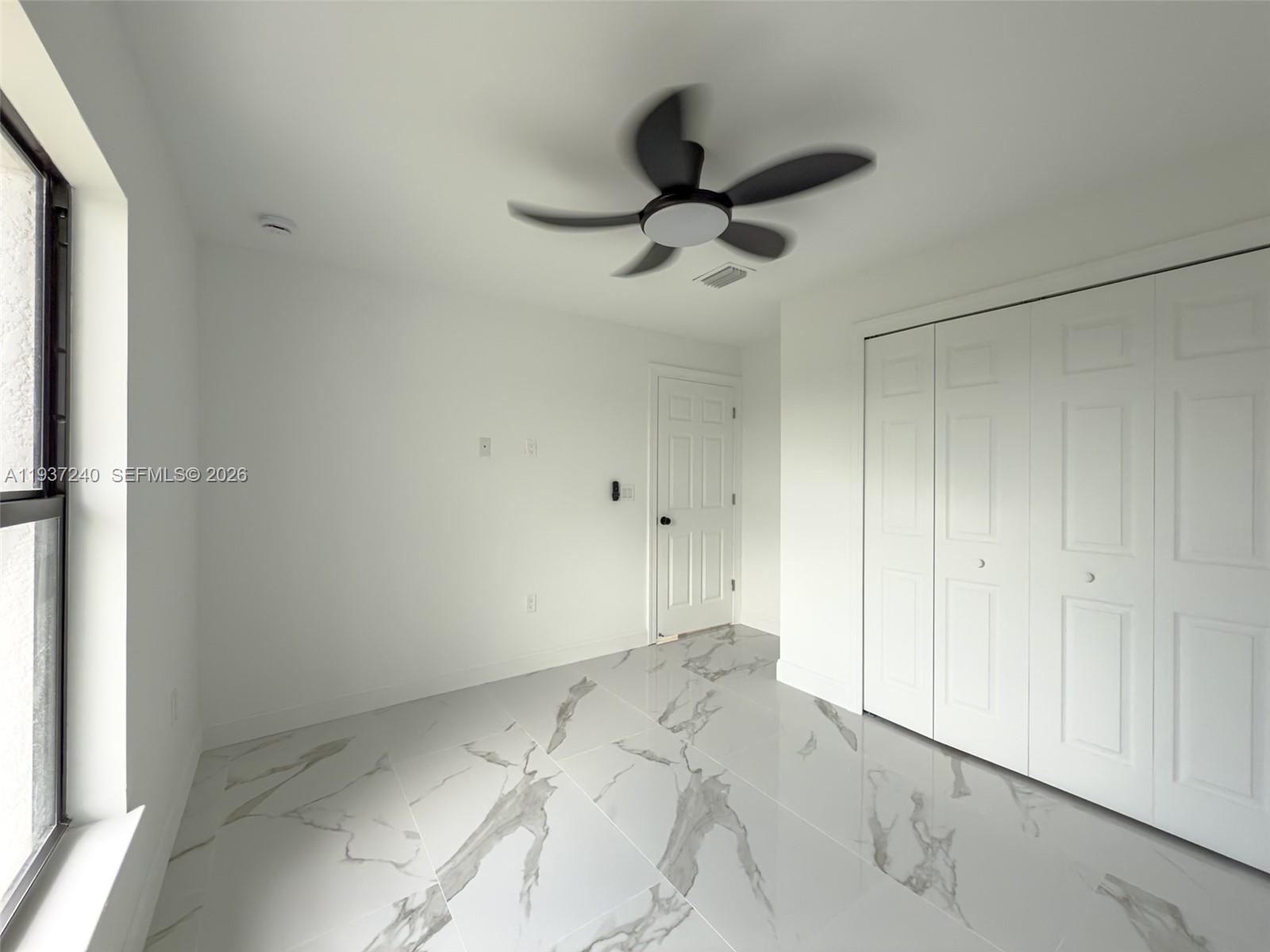 842-844 Alabama Road South Lehigh Acres, FL 33974 - Photo 30 of 40 a view of a room with a ceiling fan and hardwood floor