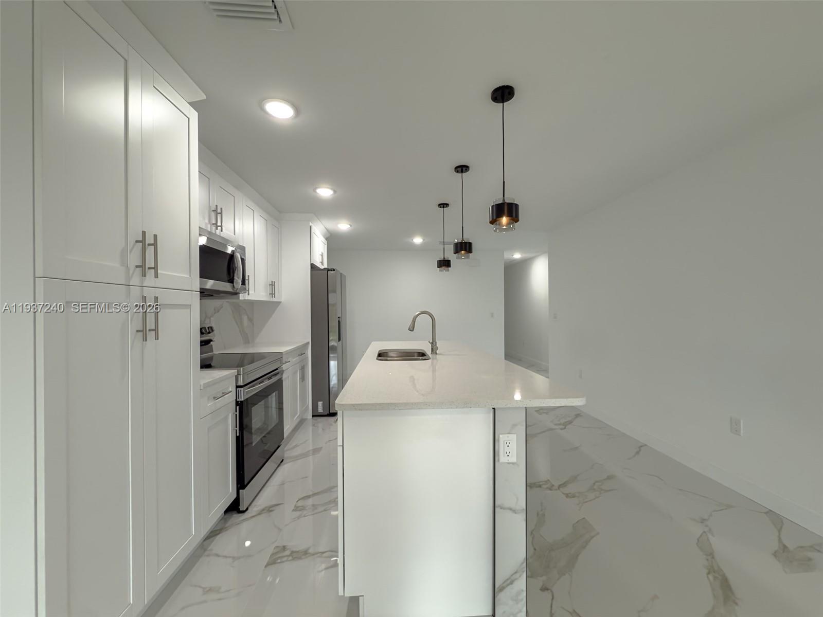 842-844 Alabama Road South Lehigh Acres, FL 33974 - Photo 35 of 40 a kitchen with a sink stainless steel appliances and cabinets