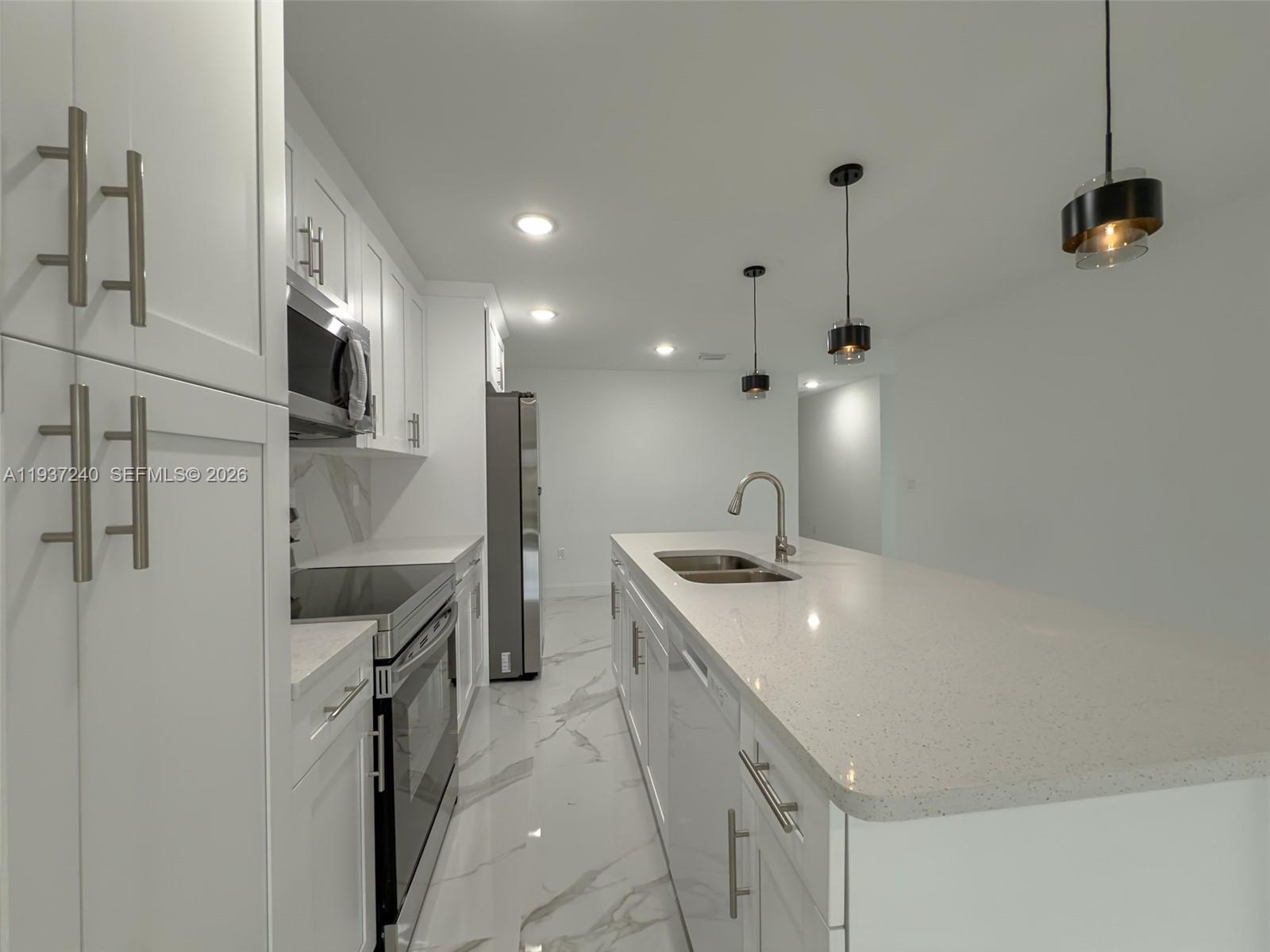 842-844 Alabama Road South Lehigh Acres, FL 33974 - Photo 36 of 40 a kitchen with a sink and refrigerator