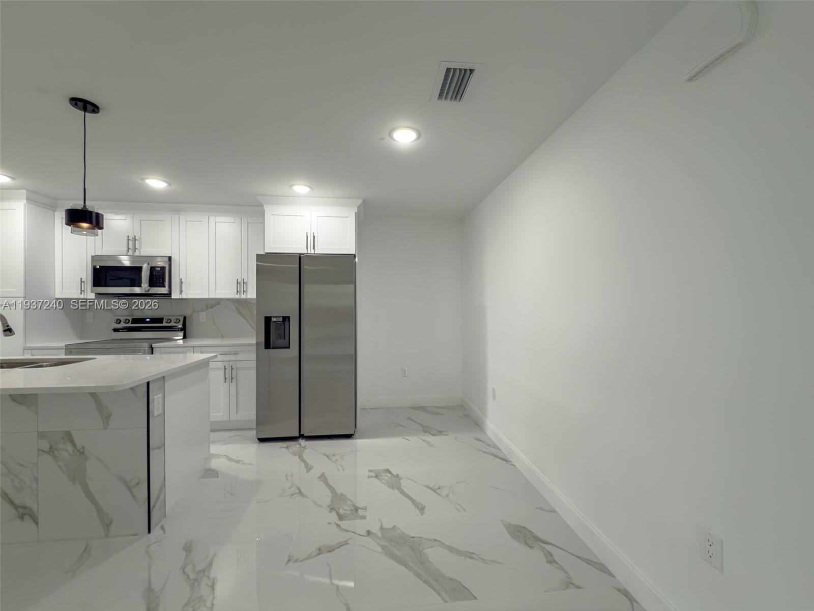 842-844 Alabama Road South Lehigh Acres, FL 33974 - Photo 40 of 40 a kitchen with refrigerator and cabinets