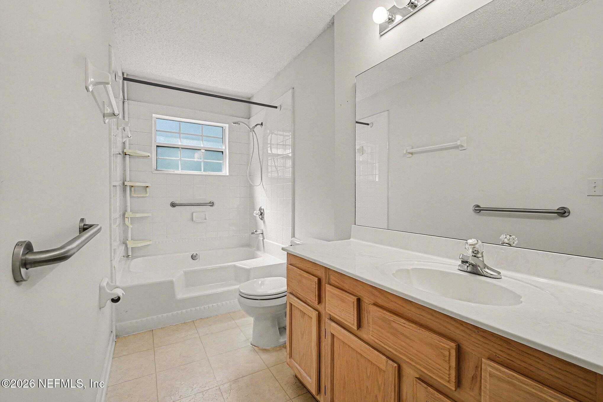 11958 Swooping Willow Road Jacksonville, FL 32223 - Photo 18 of 31 a bathroom with a sink a toilet and shower
