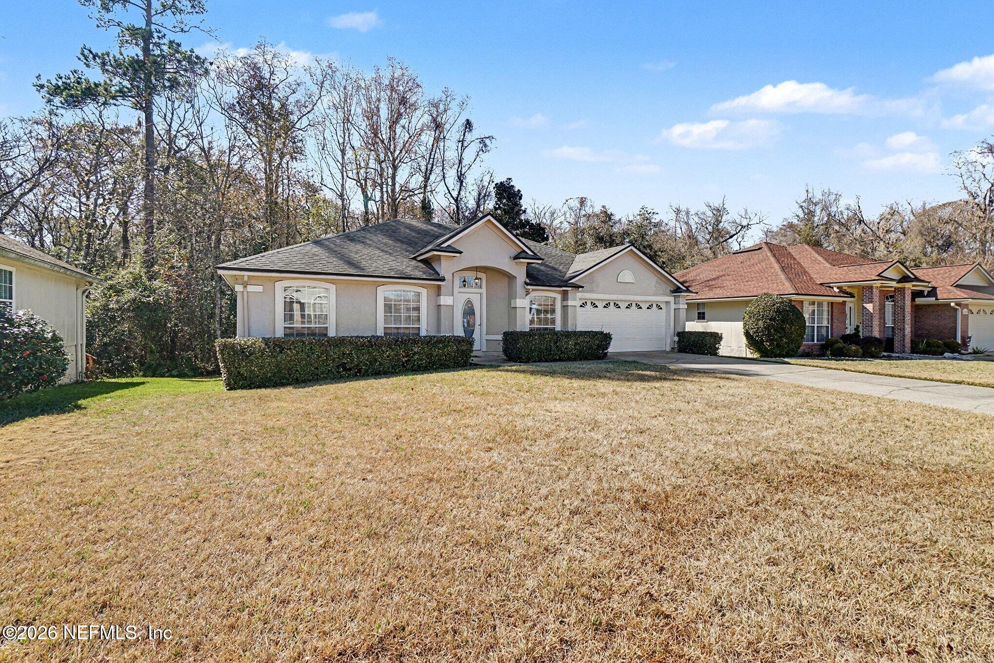 11958 Swooping Willow Road Jacksonville, FL 32223 - Photo 2 of 31 a front view of a house with a yard