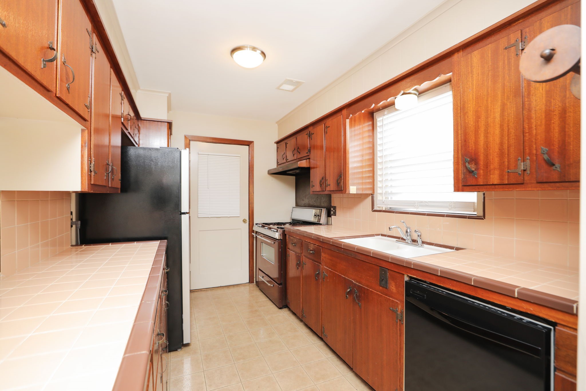7158 Sharpview Drive Houston, TX 77074 - Photo 15 of 35 a kitchen with stainless steel appliances a sink cabinets and a window