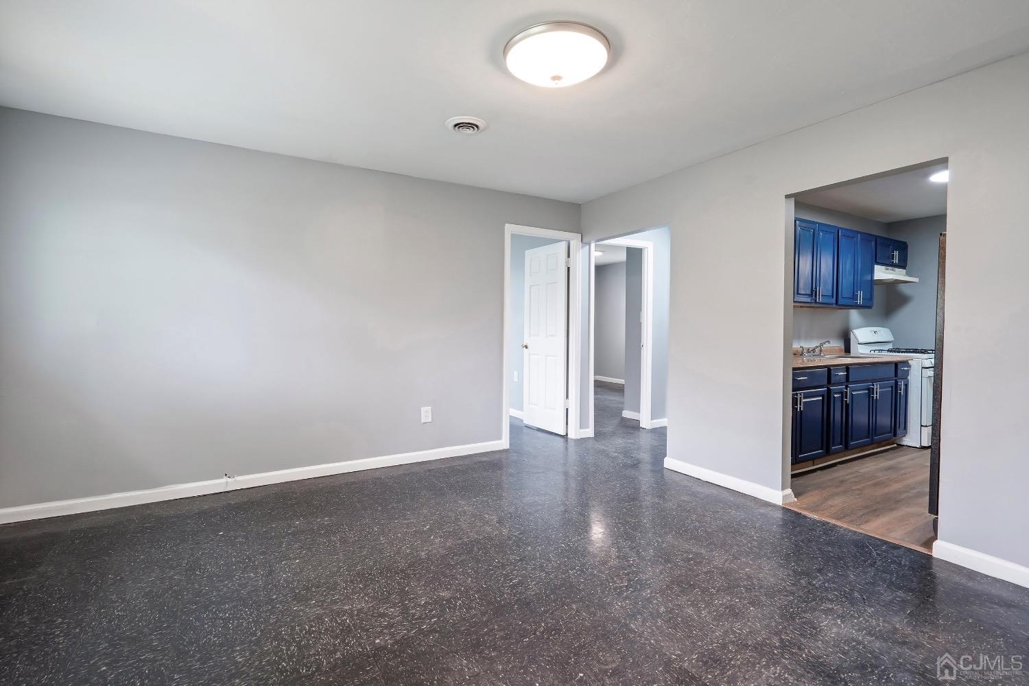 211 Kinsley Road Pemberton, NJ 08068 - Photo 2 of 15 an empty room with kitchen space and a window