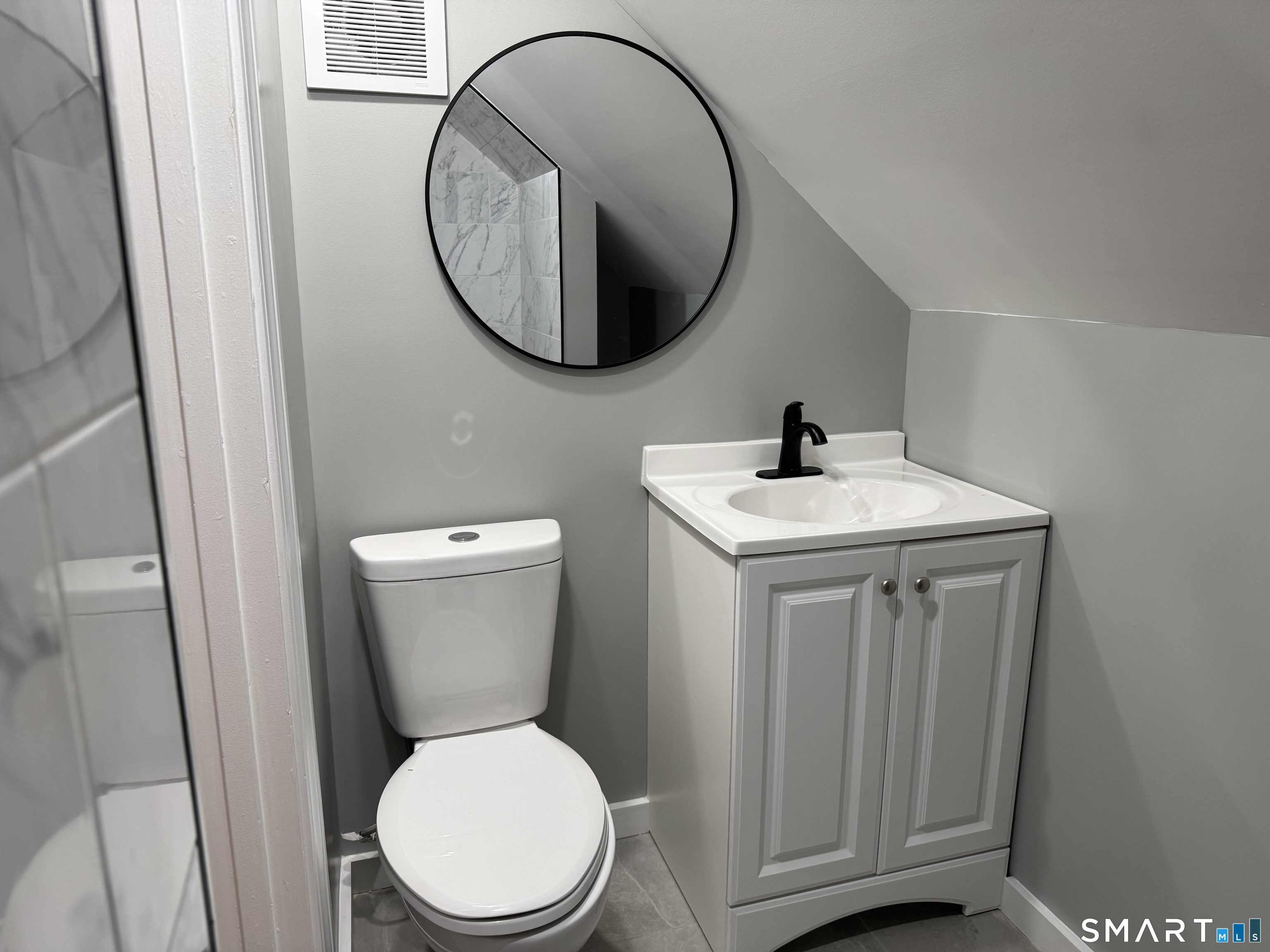 299 Linnmoore Street Hartford, CT 06106 - Photo 18 of 23 a bathroom with a toilet a sink and a mirror